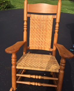 Antique wooden wicker rocking chair sitting in the sun